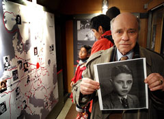 Herr Shenkman mit einem Bild von sich als Kind im Zug der ERinnerung